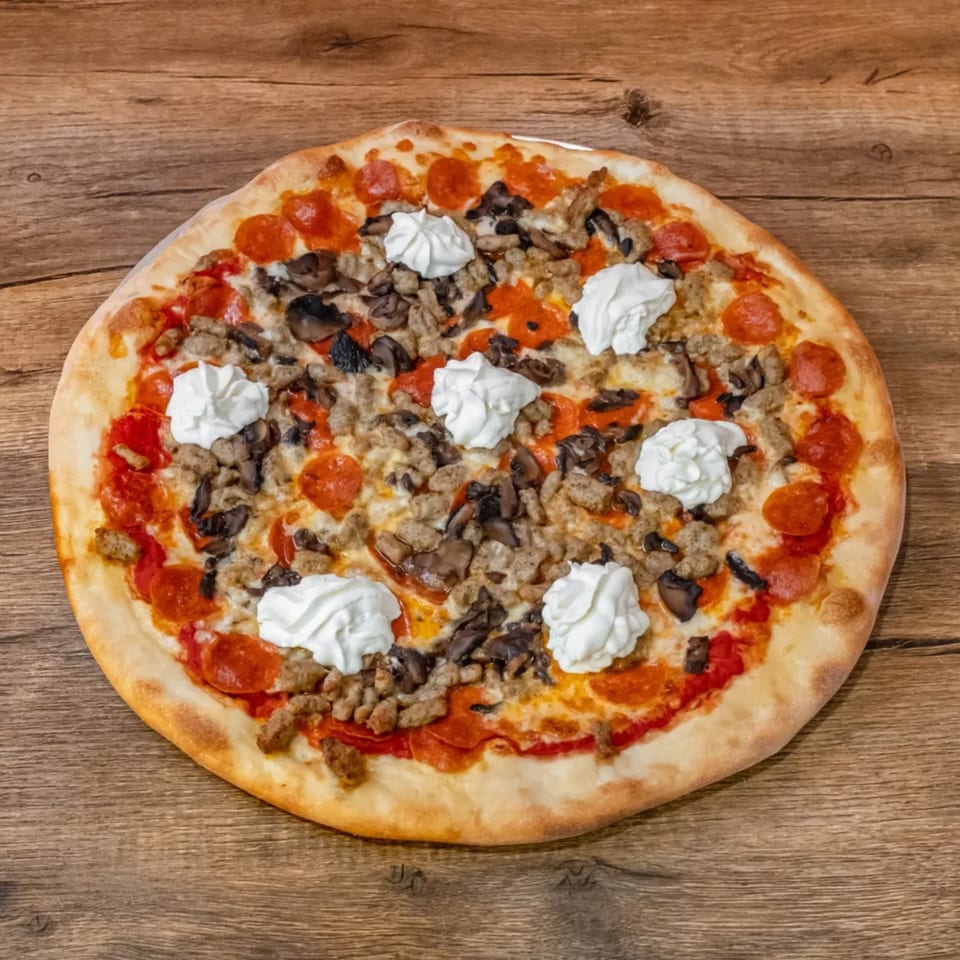 Big Oven Pizza's pepperoni, sausage, and mushroom pizza with dollops of ricotta cheese on a wooden table.